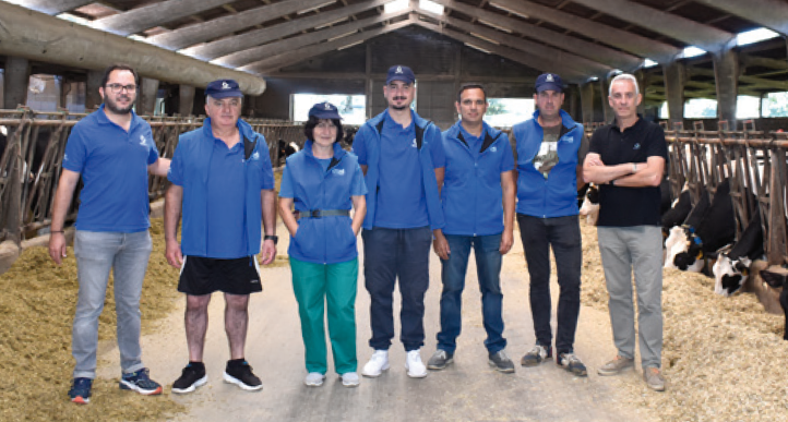 Equipo en explotación ganadera Equipo de trabajo posando en una nave ganadera