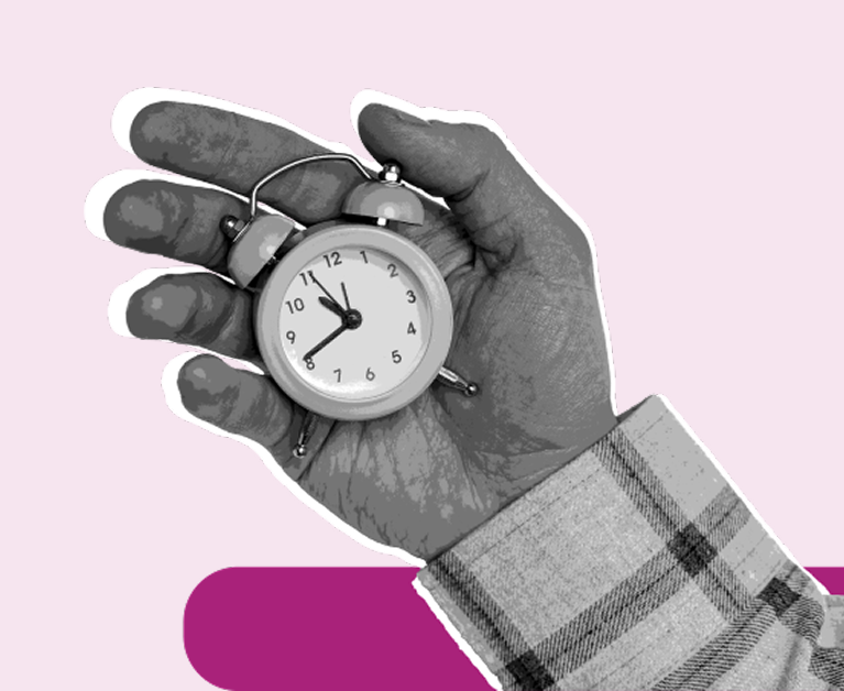 Mano sosteniendo un reloj despertador en blanco y negro